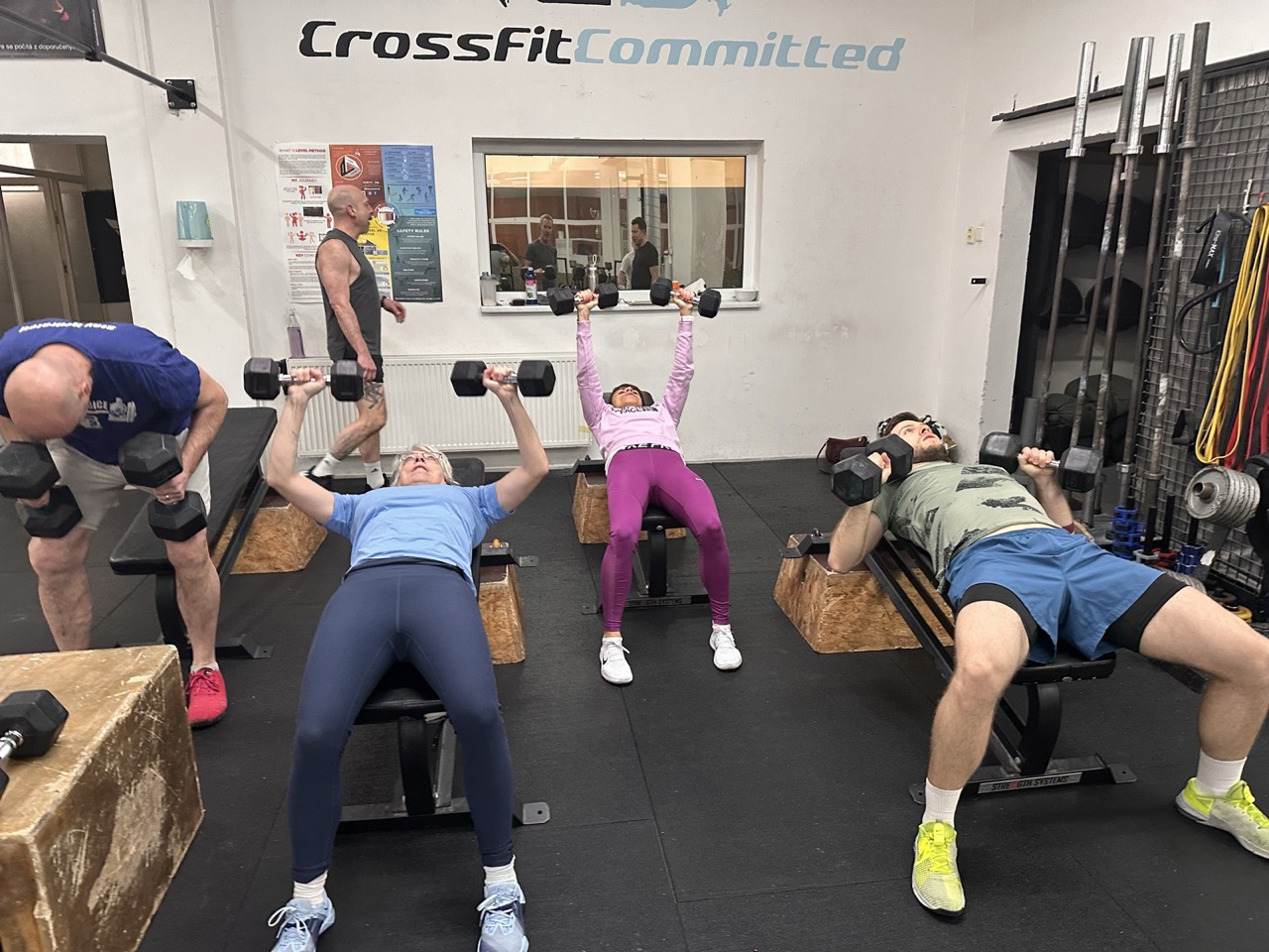 A coached class at CrossFit Committed working through a dumbbell bench press